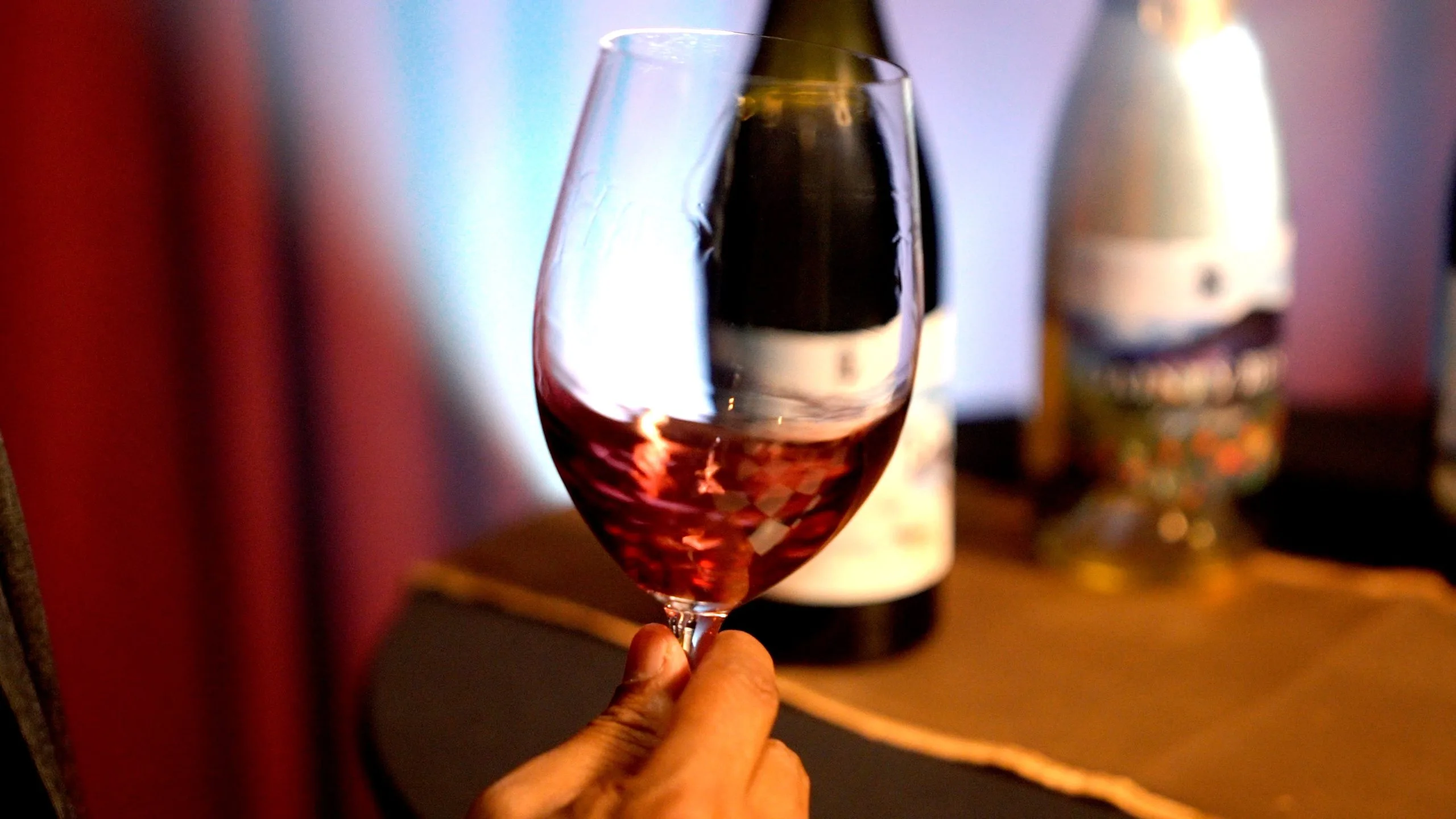 Glass of red South African wine with candlelit backdrop at iGOLI’s bar in London